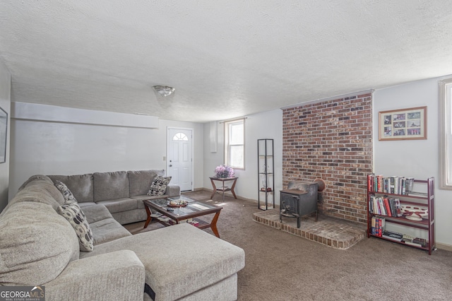 living area with baseboards, carpet, a wood stove, and a textured ceiling