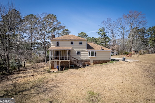 back of house with stairway, a sunroom, and a chimney