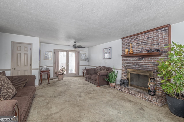 carpeted living area with ceiling fan, a brick fireplace, and a textured ceiling