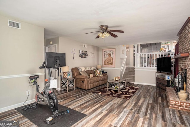 living room featuring visible vents, stairs, baseboards, and wood finished floors