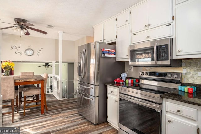 kitchen with decorative backsplash, white cabinets, stainless steel appliances, and ceiling fan