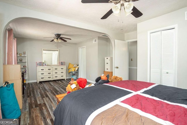 bedroom featuring baseboards, arched walkways, a textured ceiling, and wood finished floors