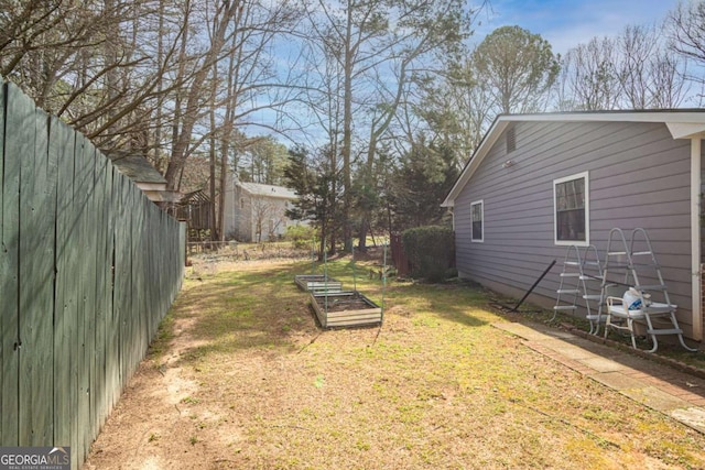 view of yard with fence and a garden