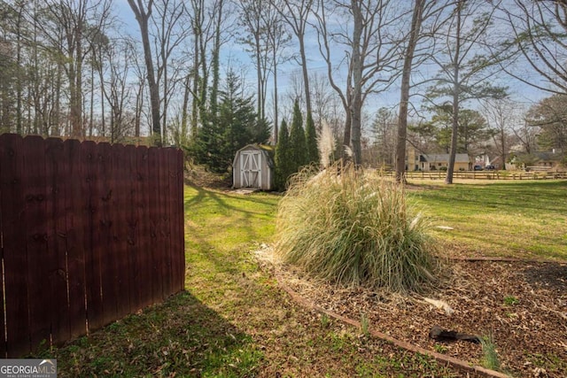 view of yard with a storage shed, an outdoor structure, and fence