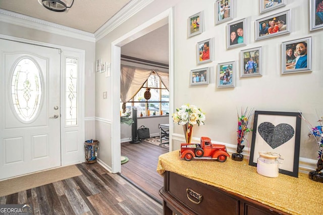 entrance foyer featuring a textured ceiling, dark wood-type flooring, baseboards, and ornamental molding