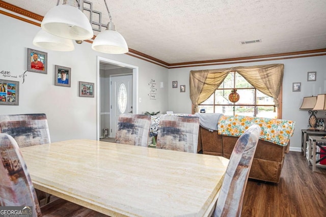 dining room featuring visible vents, a textured ceiling, dark wood-style floors, and ornamental molding