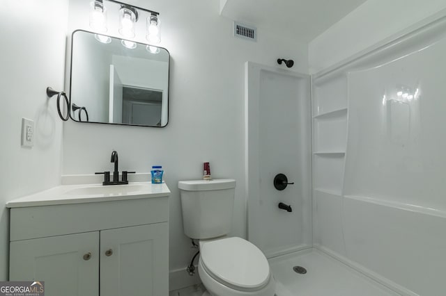 bathroom with vanity, toilet, visible vents, and walk in shower