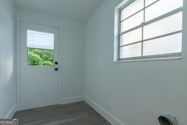 doorway featuring baseboards and wood finished floors