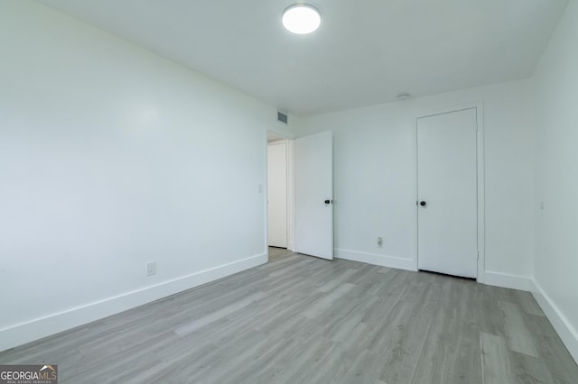 unfurnished bedroom featuring visible vents, baseboards, and wood finished floors