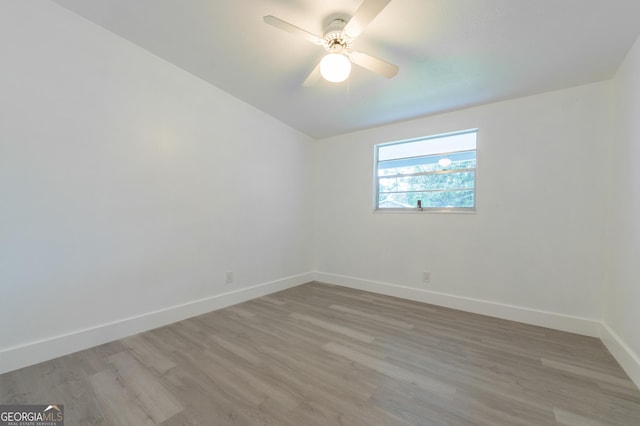 unfurnished room featuring baseboards, light wood-style floors, and ceiling fan