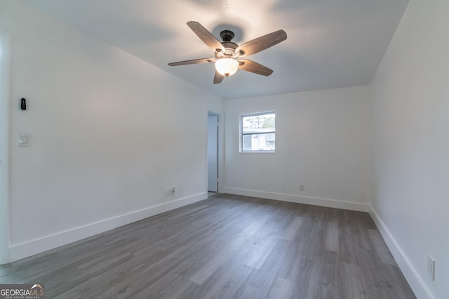 unfurnished room featuring ceiling fan, baseboards, and wood finished floors