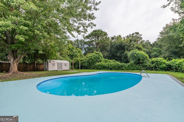 view of pool featuring an outdoor structure, a storage unit, a fenced in pool, and fence