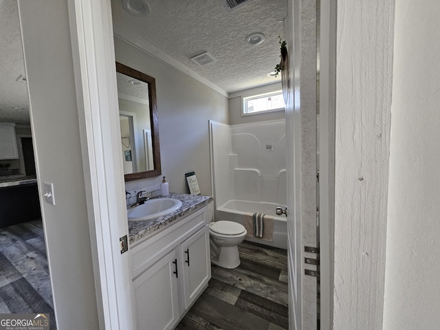 full bath featuring shower / washtub combination, toilet, vanity, wood finished floors, and a textured ceiling