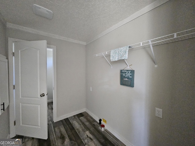 washroom with dark wood finished floors, a textured ceiling, baseboards, and ornamental molding