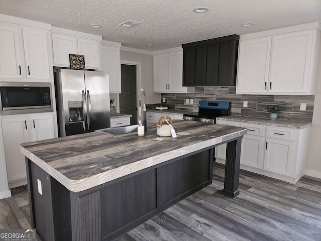 kitchen with visible vents, stainless steel appliances, white cabinets, decorative backsplash, and dark wood-style flooring