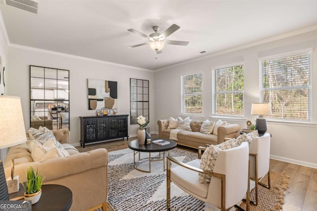 living room featuring baseboards, wood finished floors, visible vents, and ornamental molding