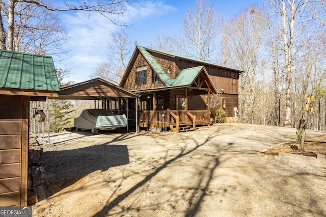 back of house featuring a detached carport and driveway