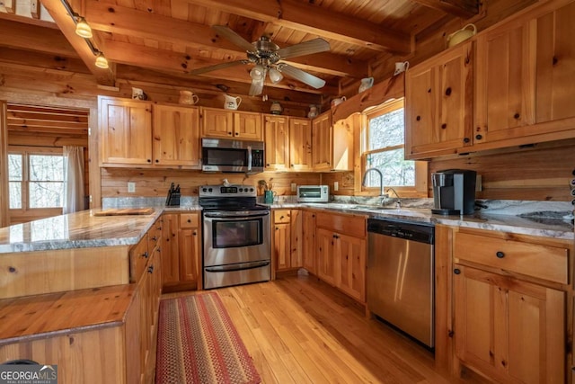 kitchen with wooden ceiling, light wood-style flooring, appliances with stainless steel finishes, and a sink