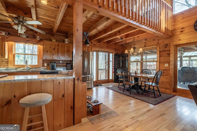 kitchen featuring wooden walls, light wood finished floors, and freestanding refrigerator