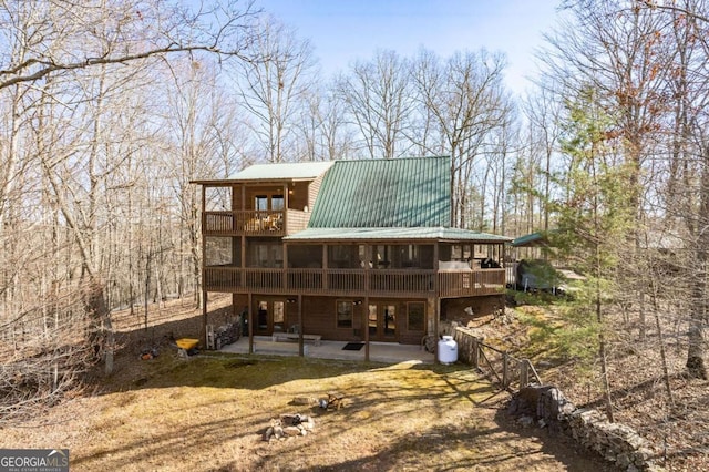 back of property with a patio, a balcony, and metal roof