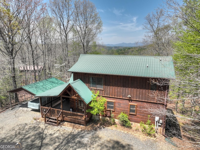 exterior space featuring a mountain view, a carport, driveway, and metal roof