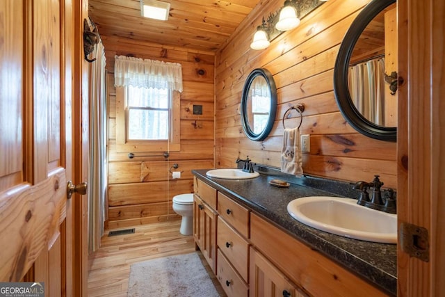 bathroom featuring wood finished floors, wood ceiling, visible vents, and a sink