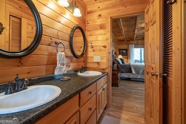 full bathroom with wood ceiling, wooden walls, wood finished floors, and a sink