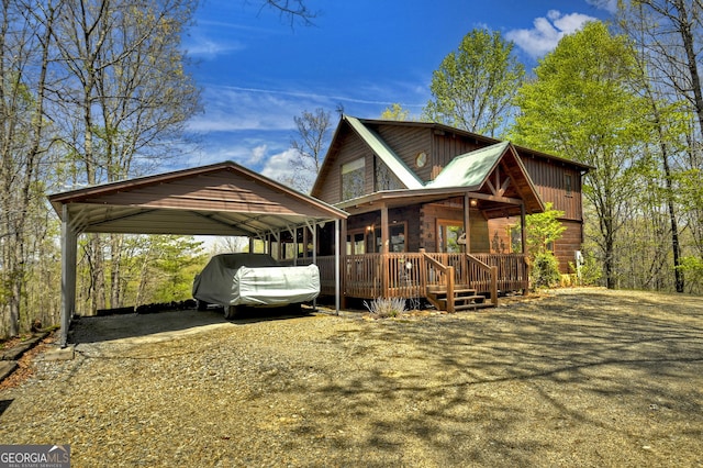exterior space featuring a wooden deck, driveway, and a detached carport