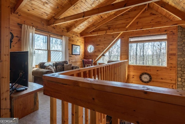 interior space featuring wooden ceiling, carpet, wood walls, and vaulted ceiling with beams