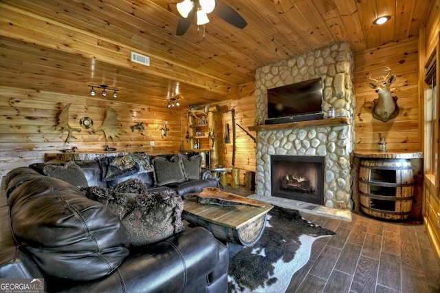 living area with wood finished floors, visible vents, wooden ceiling, a fireplace, and ceiling fan
