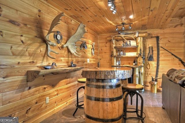 bar with wood ceiling, wooden walls, wood finished floors, and bar