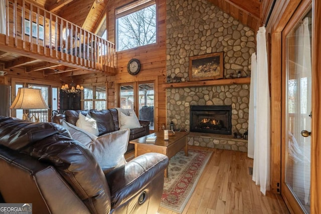 living room with wooden ceiling, wooden walls, a fireplace, and light wood-type flooring