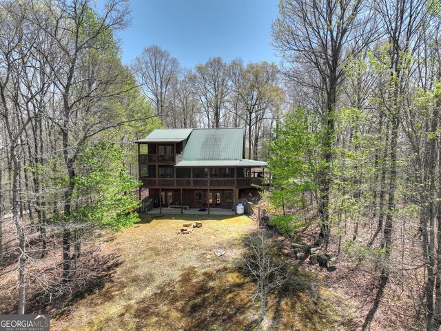 back of property featuring a deck and metal roof