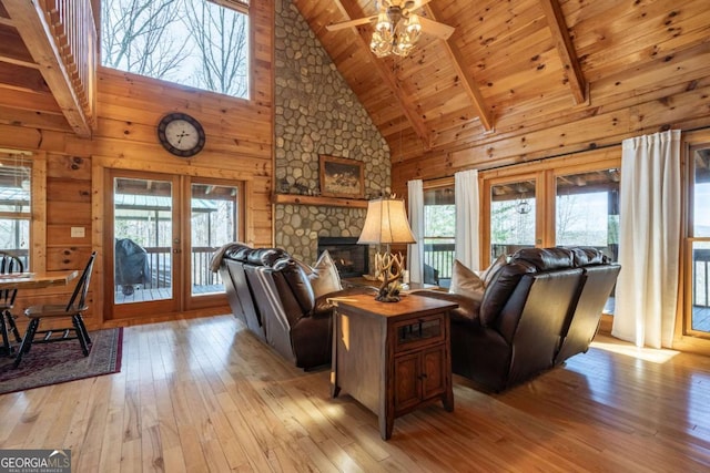 living area featuring wooden walls, light wood-style flooring, french doors, and wood ceiling