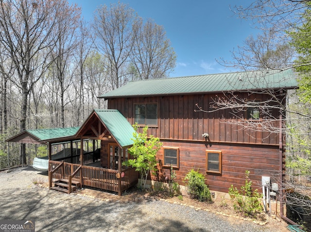 exterior space with board and batten siding and metal roof
