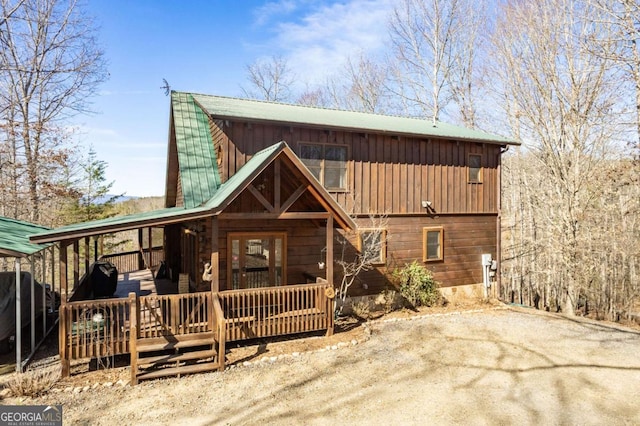 view of front of property featuring a carport, covered porch, driveway, and metal roof