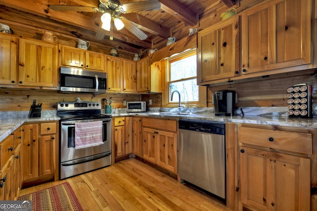 kitchen featuring stainless steel appliances, wooden ceiling, a sink, beamed ceiling, and light wood-style floors