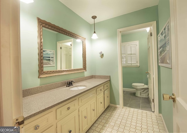 bathroom with vanity, tile patterned floors, toilet, and baseboards