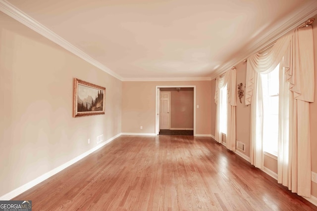 unfurnished room with baseboards, wood finished floors, and crown molding