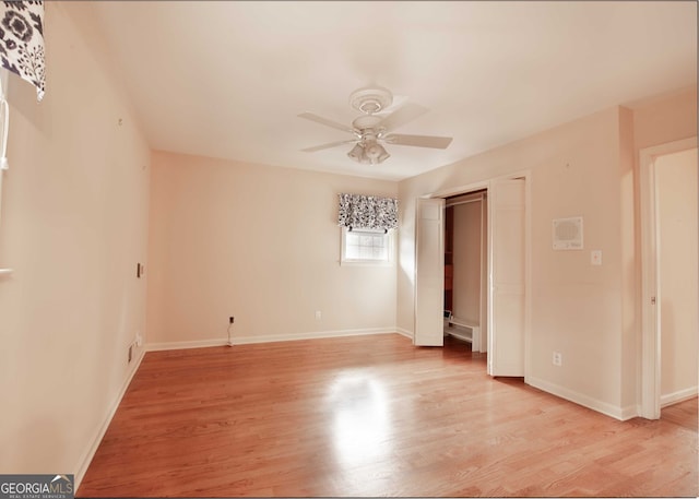 empty room with baseboards, ceiling fan, and light wood finished floors