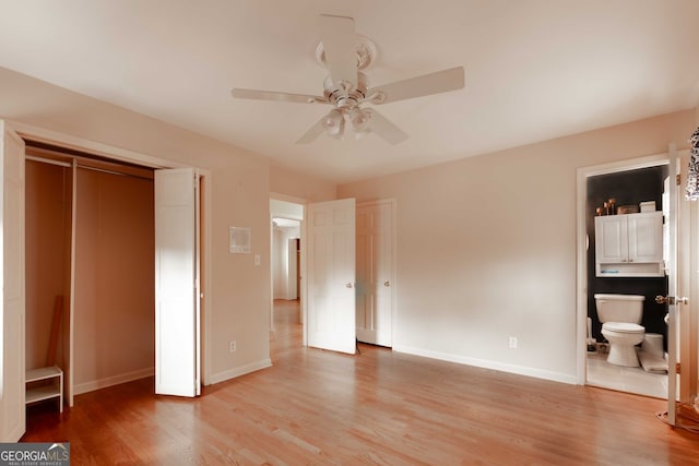 unfurnished bedroom featuring ceiling fan, ensuite bathroom, light wood-type flooring, and baseboards