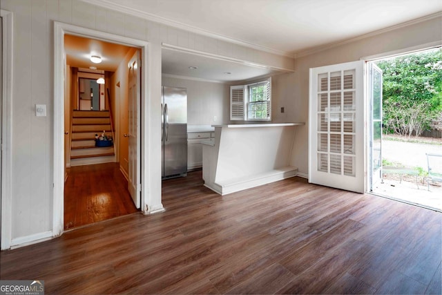 unfurnished dining area with baseboards, ornamental molding, and dark wood-style flooring