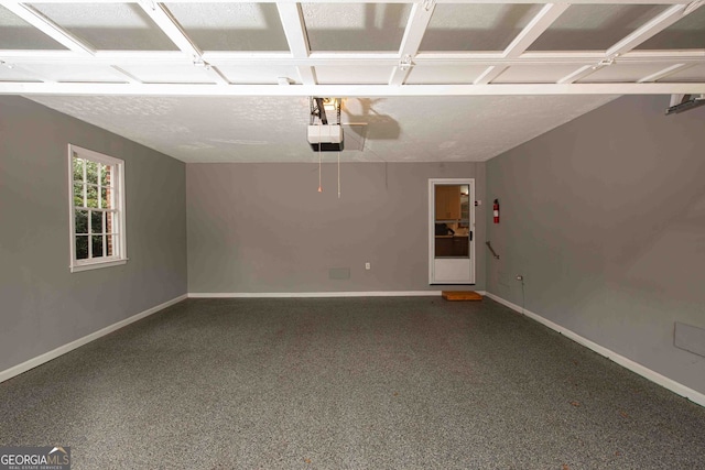 garage featuring a garage door opener and baseboards