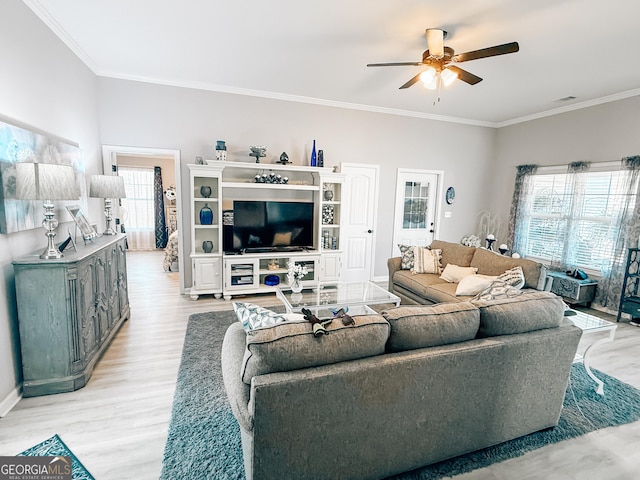 living room featuring visible vents, crown molding, baseboards, ceiling fan, and light wood-type flooring