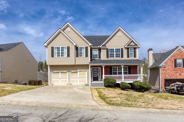 view of front facade with a front yard, an attached garage, covered porch, and driveway