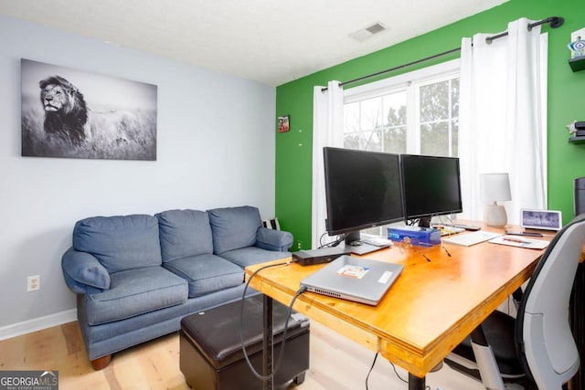 office with visible vents, baseboards, a textured ceiling, and wood finished floors