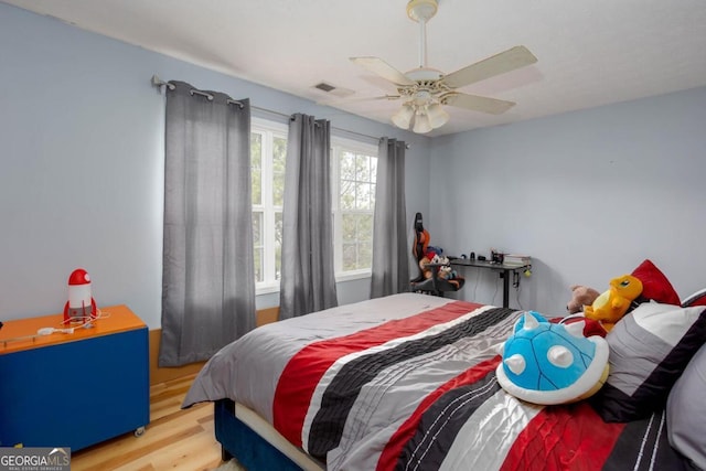 bedroom featuring wood finished floors, visible vents, and ceiling fan