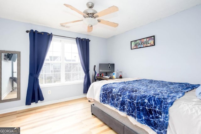 bedroom with visible vents, ceiling fan, baseboards, and wood finished floors