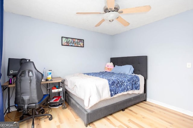 bedroom featuring ceiling fan, baseboards, and wood finished floors