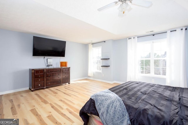 bedroom with visible vents, ceiling fan, baseboards, and wood finished floors